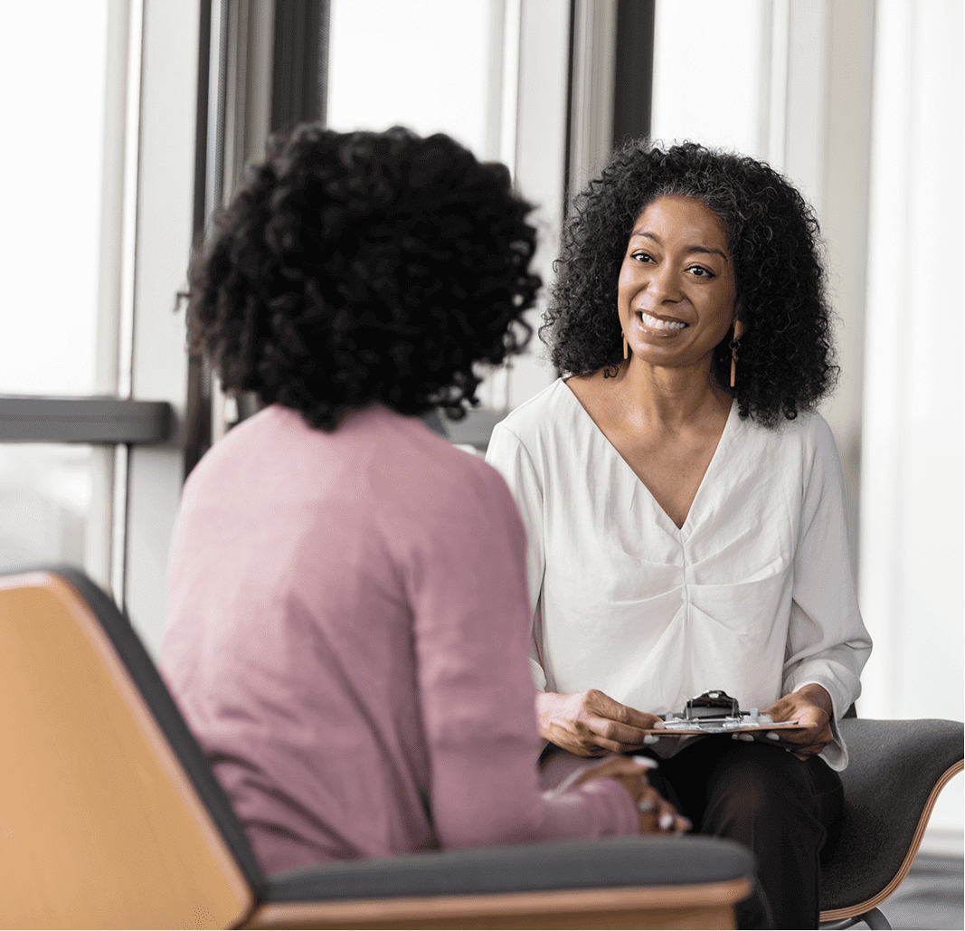 Two women having a conversation in office.